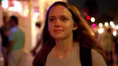 Genç ve güzel bir kadın geceleri Key West 'te Duval caddesinde yürüyor.