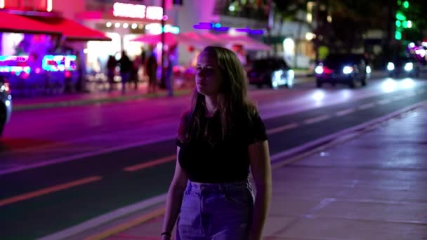 晚上在迈阿密海滩开五彩缤纷的海洋大道-年轻女子沿街散步 — 图库视频影像