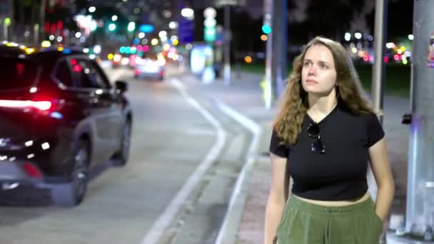 Mujer joven caminando por la calle por la noche — Vídeos de Stock