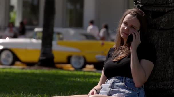 Mujer joven se relaja al sol en el paseo marítimo de Miami South Beach — Vídeos de Stock