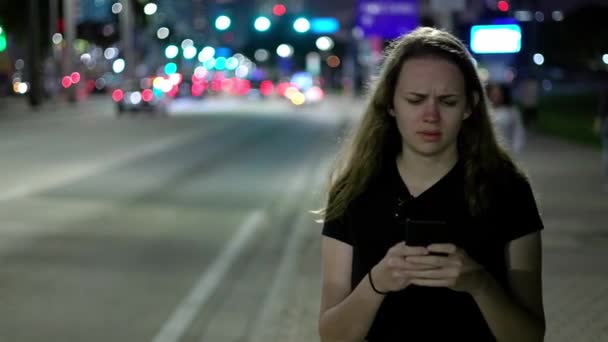Jonge vrouw die 's nachts over straat loopt — Stockvideo