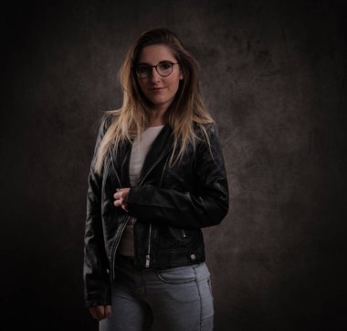 Koyu gri arka planda genç ve çekici bir kadının yakın çekimi.