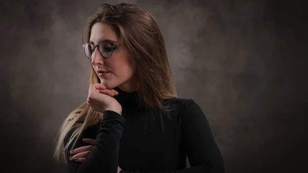 Nahaufnahme einer jungen attraktiven Frau vor dunkelgrauem Hintergrund — Stockfoto