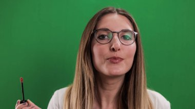 Genç ve güzel kadın dudaklarını yapıyor.