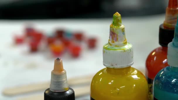 Kolorowe butelki atramentu w studio tatuażu — Wideo stockowe