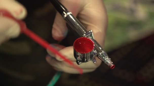 Enchendo uma pistola de aerógrafo com tinta colorida - tatuagens de aerógrafo — Vídeo de Stock