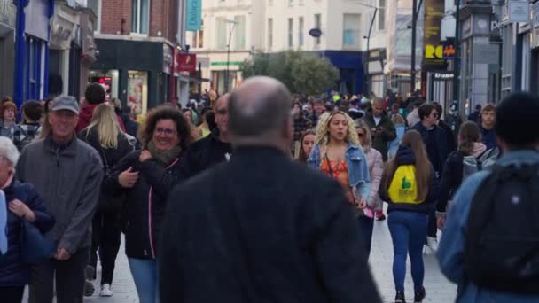 Crowd of people walking through a busy pedestrian zone - Grafton Street Dublin in slow motion - DUBLIN, IRELAND - APRIL 20, 2022 — Vídeo de Stock