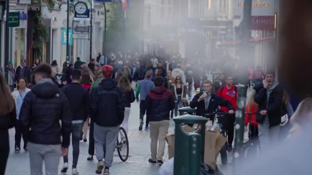 Crowd of people walking through a busy pedestrian zone - Grafton Street Dublin in slow motion - DUBLIN, IRELAND - APRIL 20, 2022 — ストック動画