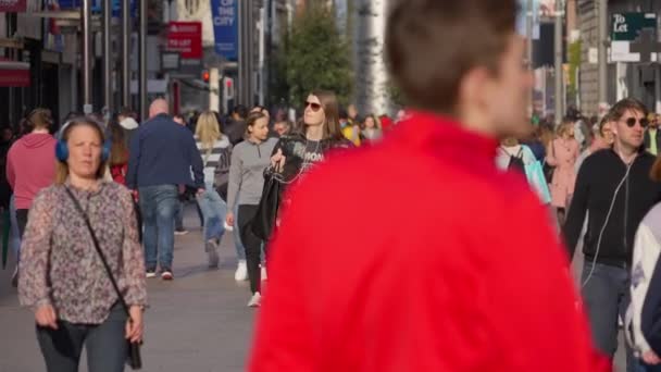 Crowd of people walking through a busy pedestrian zone - in slow motion - DUBLIN, IRELAND - APRIL 20, 2022 — Vídeos de Stock