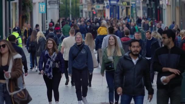 Crowd of people walking through a busy pedestrian zone - Grafton Street Dublin in slow motion - DUBLIN, IRELAND - APRIL 20, 2022 — Stock Video