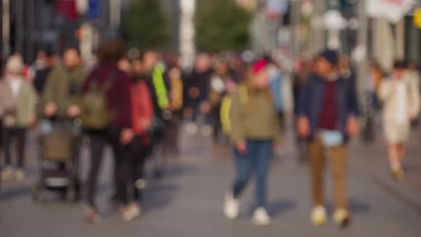 Crowd of people walking through a busy pedestrian zone - in slow motion - DUBLIN, IRELAND - APRIL 20, 2022 — ストック動画