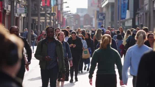 Kerumunan orang berjalan melalui zona pejalan kaki yang sibuk - Grafton Street Dublin dalam gerakan lambat - DUBLIN, IRELAND - April 20, 2022 — Stok Video