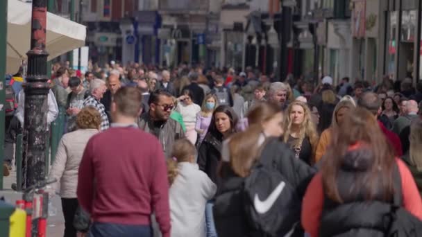 Crowd of people walking through a busy pedestrian zone - Grafton Street Dublin in slow motion - DUBLIN, IRELAND - APRIL 20, 2022 — Stock Video