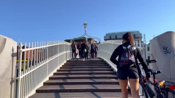 Ha Penny Bridge over River Liffey in Dublin - DUBLIN, IRELAND - APRIL 20. 2022 — Stock video