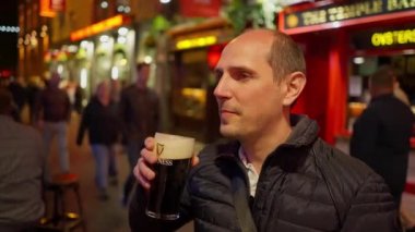 Geceleri Dublin 'in Temple Bar bölgesinde bira içen adamlar, seyahat fotoğrafçılığı.