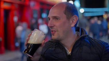 Guys drinking a beer in the Temple Bar district of Dublin by night - travel photography