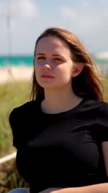 Miami Sahili 'nin kumullarında yürüyen genç bir kadın. Seyahat fotoğrafçılığı.