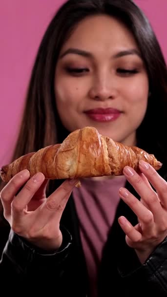 年轻女人吃着新鲜烤的法国羊角面包 工作室拍摄 — 图库视频影像