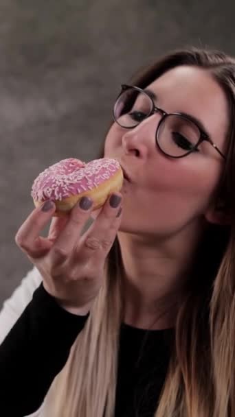 Young Woman Eats Freshly Baked Donut Studio Photography Vertical Video — Stockvideo