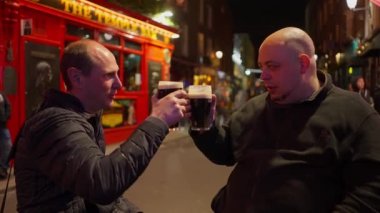 Geceleri Dublin 'in Temple Bar bölgesinde bira içen adamlar İrlanda' ya seyahat fotoğrafçılığı yapıyor.