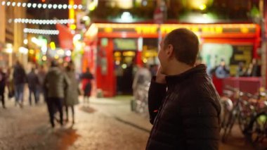 Geceleri Dublin 'in Temple Bar bölgesinde bira içen adamlar İrlanda' ya seyahat fotoğrafçılığı yapıyor.