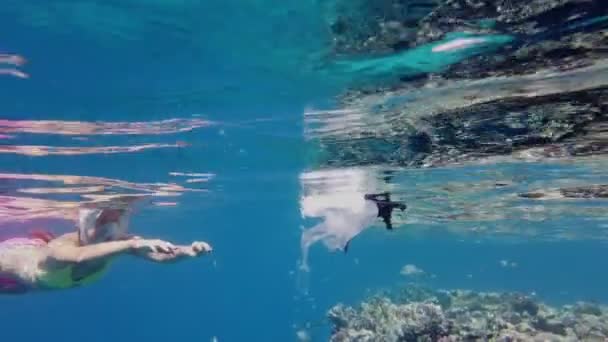 Samla skräp till havs. Volontär, flicka tonåring, i en snorkling mask, samlar flytande plast skräp, drivande plastpåsar. havsföroreningar. miljöskydd. — Stockvideo