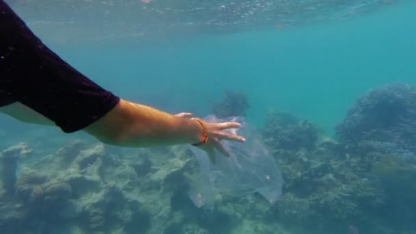 海のゴミだ。シュノーケリングマスクの少女10代のボランティアは、プラスチック製の袋を漂流し、サンゴ礁の上に浮遊ゴミを収集します。海や海の汚染。環境保護. — ストック動画