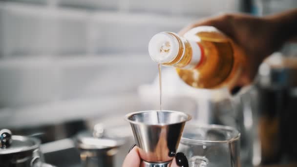 Cocinar comida. preparación de bebidas. Primer plano. barman tecnólogo vierte jarabe dulce en taza de medir de metal, para añadir a otros ingredientes. — Vídeo de stock