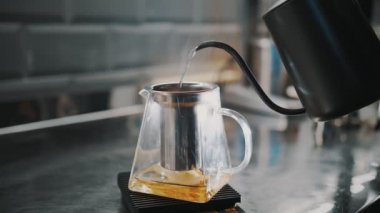 Çay içeceğim. Çay yapıyorum. Yakın plan. Çay ustası cam çaydanlığa armut dilimleriyle kaynar su döker. özel sıcak meyve çayı pişirme süreci.