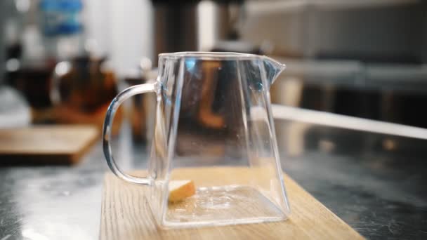 เครื่องดื่มชา ทําชา การเตรียมชาผลไม้พิเศษ ใกล้ชิด อาจารย์ชาใส่ชิ้นแอปเปิ้ลลงในกาน้ําชาแก้วเพื่อเตรียมเครื่องดื่มชาร้อนผลไม้พิเศษ . — วีดีโอสต็อก