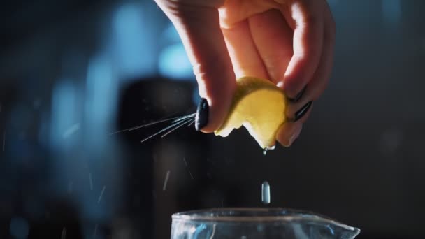 Aperta o limão. cozinhar. close-up. mãos femininas espreme o suco de meio limão, em luz de fundo — Vídeo de Stock