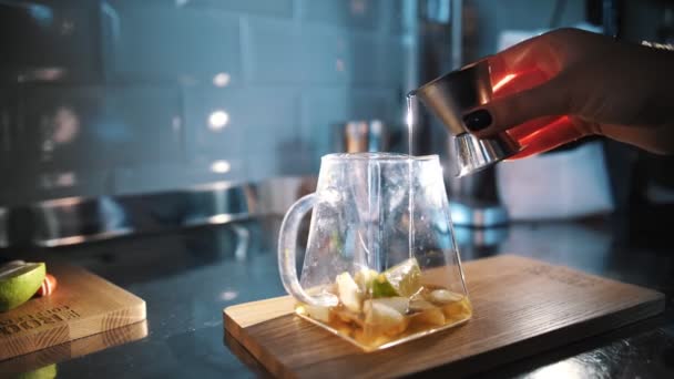 Boisson au thé. faire du thé. préparation de boissons. Gros plan. maître de thé verse sirop sucré ou jus dans une théière en verre avec des morceaux de fruits pour la préparation ultérieure de boissons spéciales de thé aux fruits chauds — Video