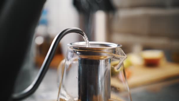 Bevanda di tè. Preparo il tè. primo piano. acqua bollente viene versato in teiera di vetro con diverse fette di frutta. processo di cottura della bevanda speciale al tè alla frutta calda. — Video Stock