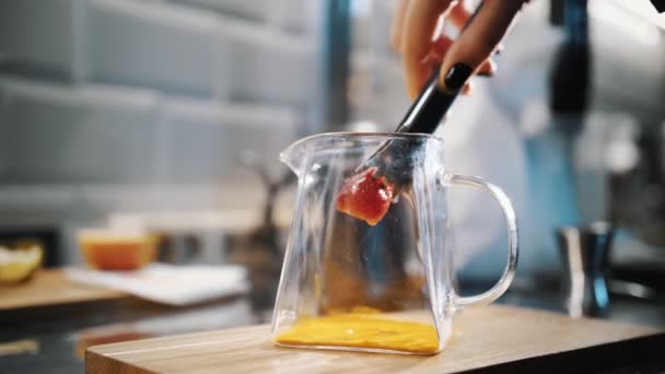 Beredning av fruktte. tedryck. Göra te. närbild. te mästare sätter en jordgubbe i ett glas tekanna för ytterligare beredning av särskild varm frukt te dryck. — Stockvideo