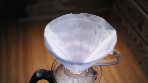Vaří se káva. detailní záběr. barista nalévá, dává čerstvě mletá kávová zrna do papírového filtru v tradičním odkapávacím zařízení — Stock video