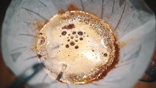 Gotejamento café cerveja. close-up. barista derrama água fervente de uma chaleira especial sobre grãos de café moídos na hora em um filtro de papel em equipamentos tradicionais de fabricação de gotejamento — Vídeo de Stock