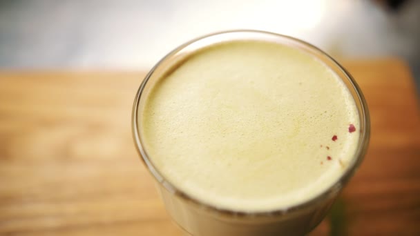 Matcha latte. Yakın plan. Üst Manzara. Kahveci kokteyl dekore eder, süt ve kibrit karışımını kuru çiçek yapraklarıyla karıştırır. — Stok video