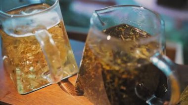 Çaydanlıkta bitki çayı. Çay içeceğim. Yakın plan. Farklı bitkisel renklerde çay ile üç bardak çaydanlık. Yapraklı çiçek, ezilmiş nane, limon, ıhlamur ve papatya çayı..