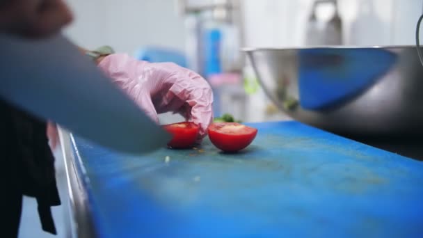 料理だ。シェフは野菜を切る。ビュッフェレストランキッチン。接近中だ。新鮮なトマトを細切りにしたシェフはプラスチック板の上に大きく鋭い包丁で. — ストック動画