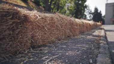 saman briketleri. Yakın plan. Araba yarışları sırasındaki güvenlik tamponları gibi yol boyunca büyük saman briketleri yerleştiriliyor.