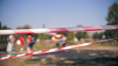 Dikkat bandı. Yakın plan. Koruma işareti. Kırmızı ve beyaz şeritli bulanık arkaplan. Çizgiyi geçme..