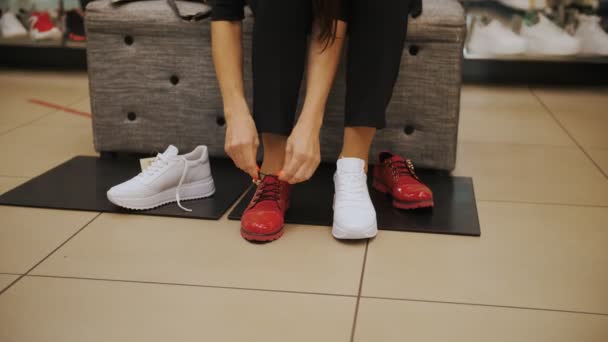 Skor. Försök med skor. närbild. gymnastikskor. Skobutiken. Vita löparskor. kvinna provar nya vita sneakers i en skoaffär — Stockvideo