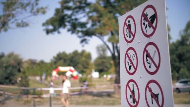 Prohibiční plakát. označení zákazu. detailní záběr. plakát se zákaznickými cedulemi v areálu parku. rozmazané pozadí — Stock video