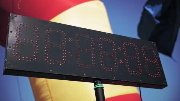 Digital timer. Counter. close-up. black light board, with red numbers of small red bulbs over black background. in park area. summer day. urban amateur sports competitions — Stock Video