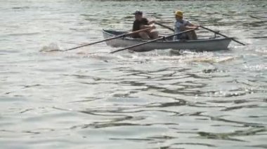 CHERKASSY, UKRAINE, AĞUSTOS 24, 2021: kürek yarışı. Çocuklar kayıkta kürek çekiyor güneşli bir yaz gününde sakin bir nehir boyunca yelken açıyorlar. Çocuklar kano yapıyor.