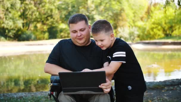 Fædre dag. Far og søn. far og lille søn tilbringer tid sammen, have det sjovt. person med et handicap. kørestolsbruger. mennesker med særlige behov. – Stock-video