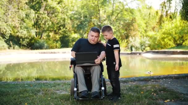 Den otců. táta a syn. Táta a malej syn spolu tráví čas a baví se. osoba se zdravotním postižením. lidé se zvláštními potřebami. uživatel invalidního vozíku. — Stock video