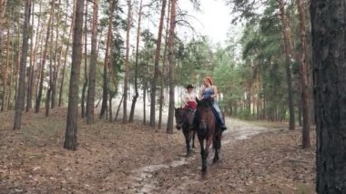 Igbt insanlarının hayatı. Gökkuşağı. Aynı cinsiyette aşk. Lezbiyen kadınların genç çifti ortak bir hobiyle meşgul, ata biniyorlar. Kız arkadaşlar ormanda at biniyor.