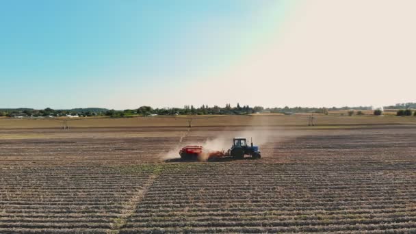 ジャガイモの収穫。ポテト・ハーベスター。ジャガイモ収穫機のトラクターである農業機械は、畑でジャガイモを収穫しています。スマート農業。空の景色。晴れた秋の日 — ストック動画