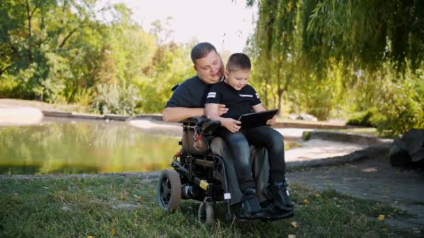 Pappadagen. Pappa och son. Pappa och lille son umgås och har kul. person med funktionshinder. personer med särskilda behov. rullstolsanvändare. — Stockvideo